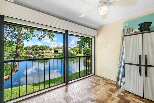 unfurnished sunroom with a water view and ceiling fan