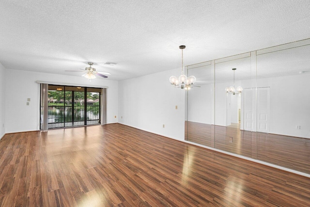 empty room featuring ceiling fan with notable chandelier, wood-type flooring, and a textured ceiling