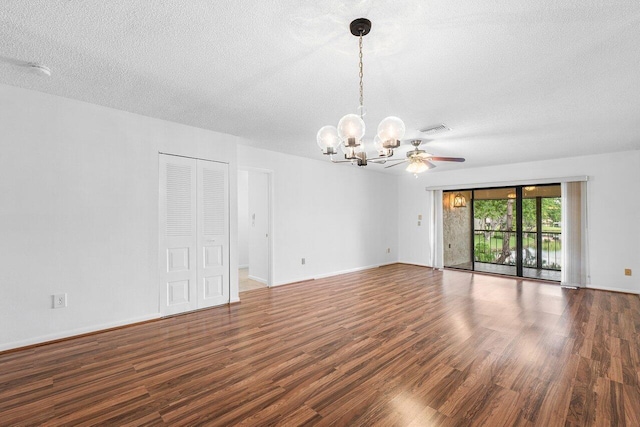 spare room featuring a textured ceiling, ceiling fan with notable chandelier, and dark wood-type flooring