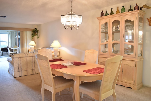 dining room with a notable chandelier and light colored carpet