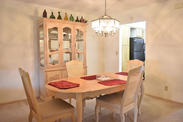 carpeted dining area with a chandelier and a textured ceiling