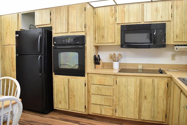 kitchen with light hardwood / wood-style floors, black appliances, and light brown cabinets