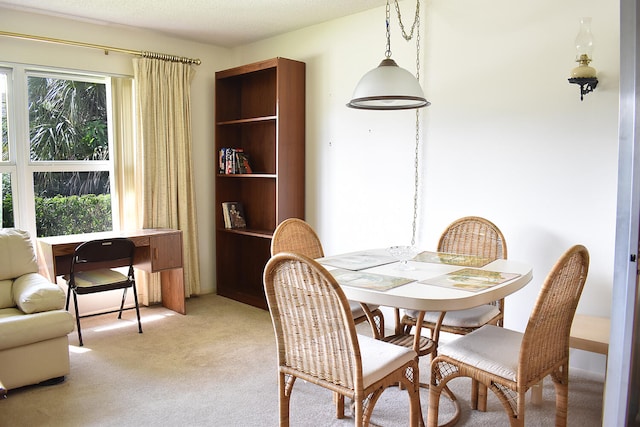 dining room with light carpet and a textured ceiling