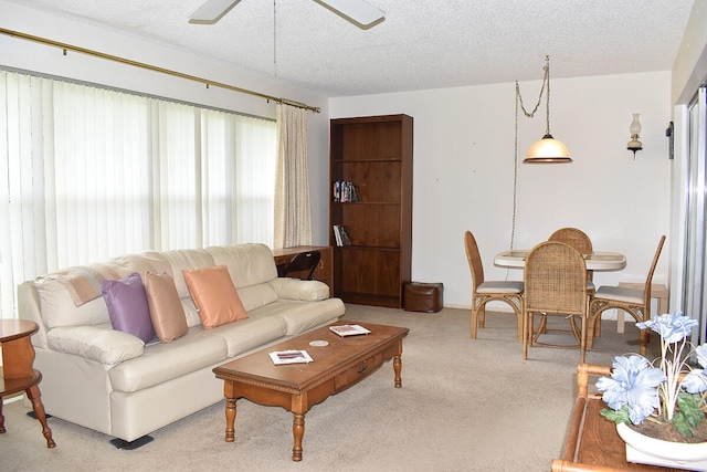 carpeted living room featuring a textured ceiling and ceiling fan