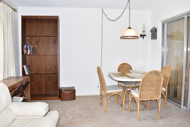 carpeted dining space with a textured ceiling