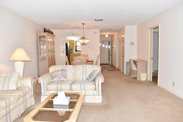 carpeted living room featuring a textured ceiling and a chandelier