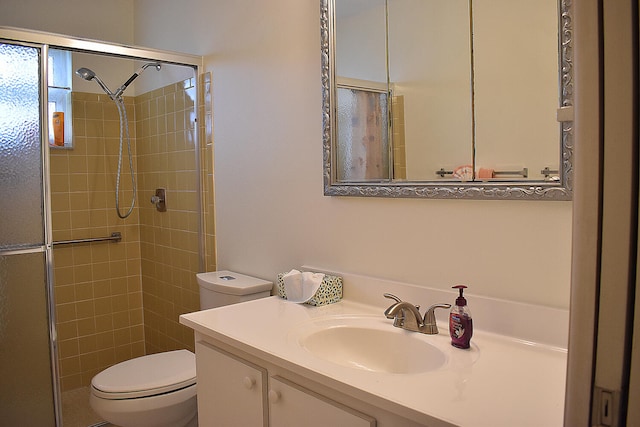 bathroom featuring vanity, toilet, and an enclosed shower