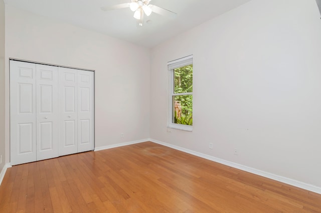 unfurnished bedroom featuring ceiling fan, a closet, and hardwood / wood-style floors