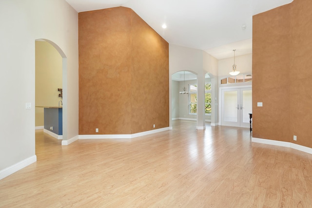 interior space featuring light hardwood / wood-style floors, french doors, and high vaulted ceiling