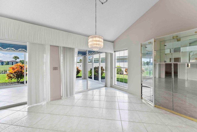 tiled empty room featuring an inviting chandelier and lofted ceiling