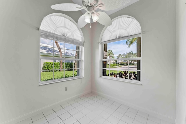 tiled spare room with ceiling fan and a wealth of natural light