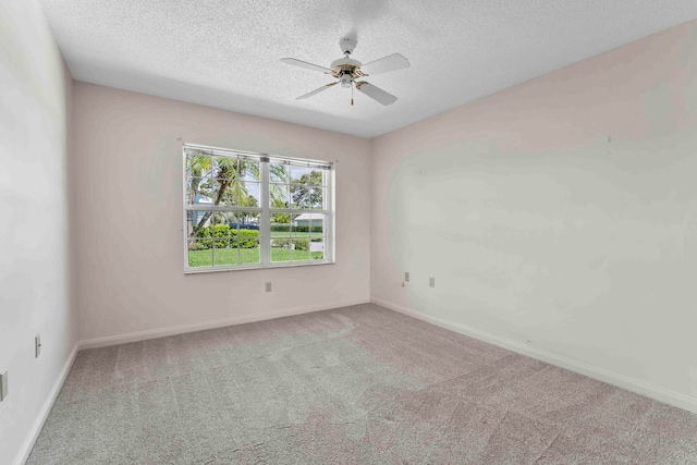 carpeted empty room with ceiling fan and a textured ceiling