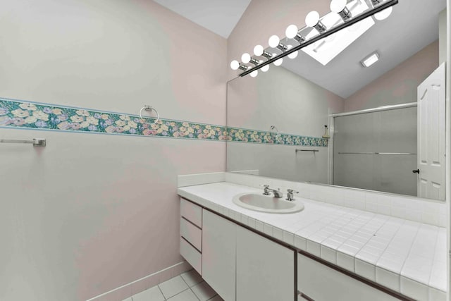 bathroom with vanity, tile patterned flooring, lofted ceiling with skylight, and an enclosed shower