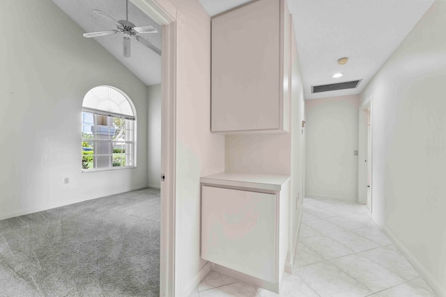 hallway featuring light carpet and lofted ceiling