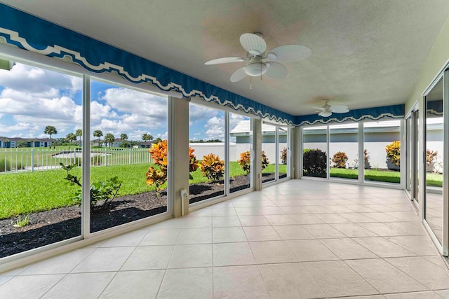 unfurnished sunroom with ceiling fan