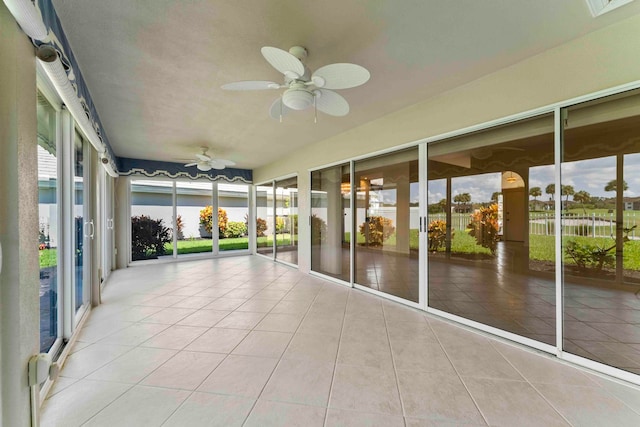 unfurnished sunroom with ceiling fan