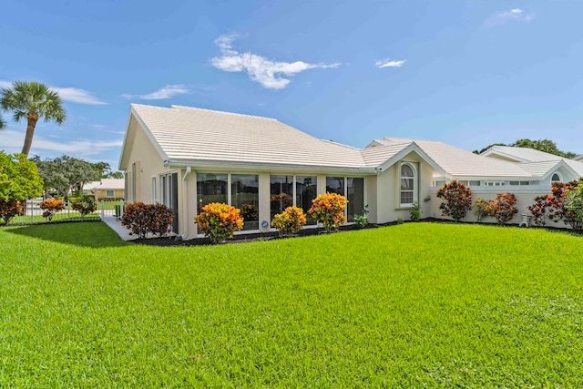 back of house featuring a garage and a yard