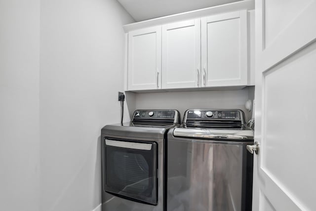 laundry room with independent washer and dryer and cabinets