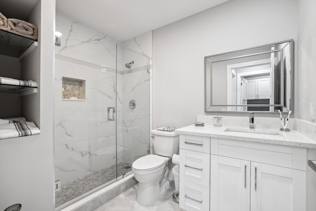 bathroom featuring vanity, toilet, and a shower with door