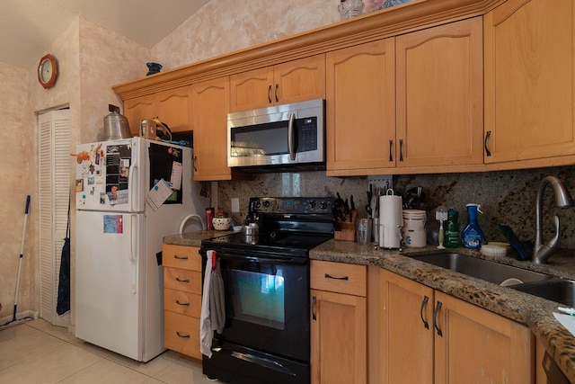 kitchen with white refrigerator, light tile patterned flooring, sink, lofted ceiling, and black / electric stove