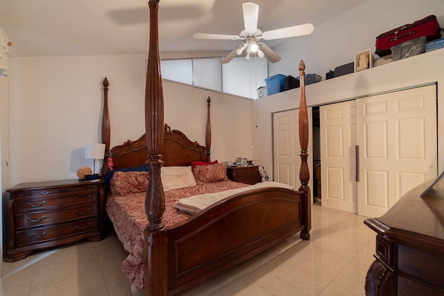 bedroom featuring ceiling fan, light tile patterned floors, a closet, and vaulted ceiling