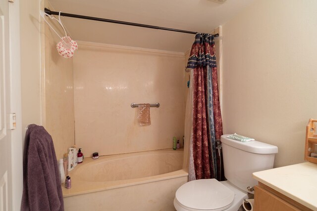 full bathroom with shower / tub combo with curtain, vanity, and toilet