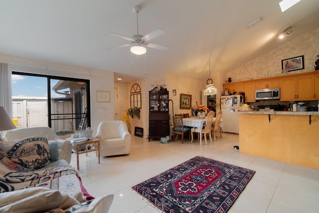 tiled living room featuring ceiling fan, a skylight, and high vaulted ceiling