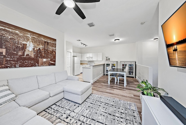 living room featuring light wood-type flooring and ceiling fan