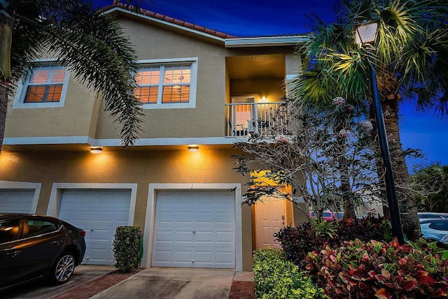 view of property featuring a balcony and a garage