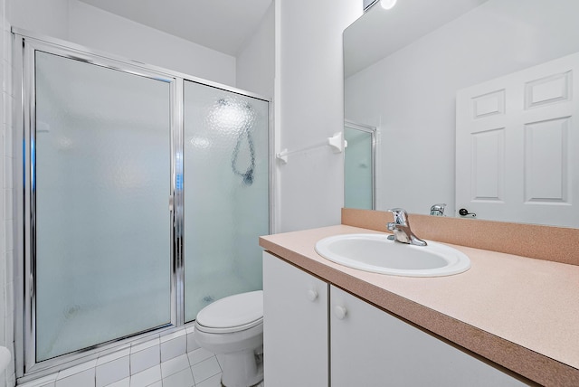 bathroom with vanity, a shower with shower door, toilet, and tile patterned floors