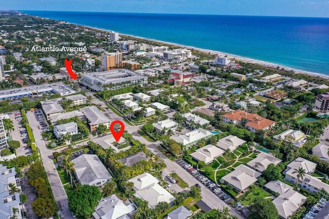 birds eye view of property featuring a water view and a beach view