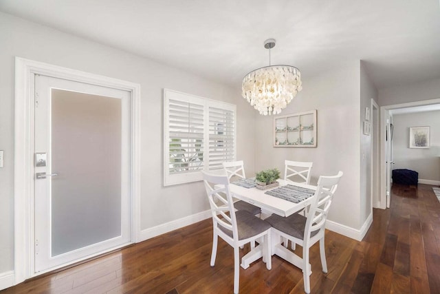 dining area with dark wood-type flooring and a chandelier