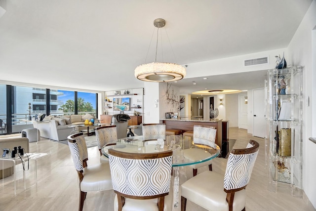 dining room featuring a wall of windows, a high end fireplace, and a water view