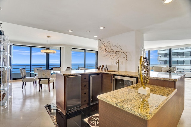 kitchen with expansive windows, wine cooler, dark tile patterned flooring, and light stone counters