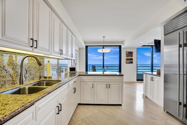 kitchen featuring sink, stainless steel built in fridge, and white cabinets