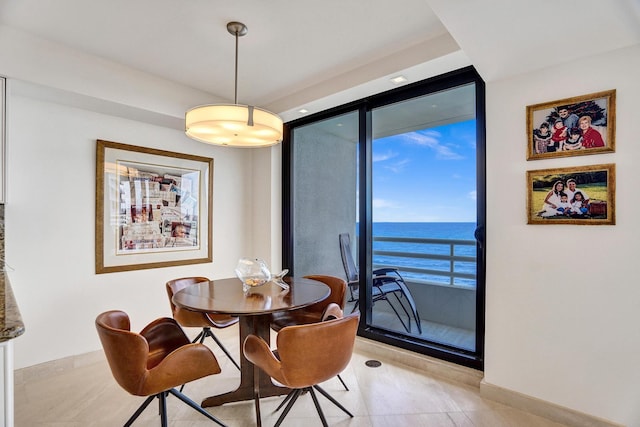 dining space with a water view and expansive windows