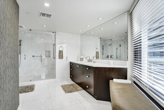 bathroom with a shower with door, vanity, and tile patterned floors