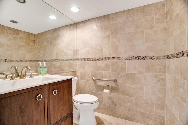 bathroom with vanity, tile walls, and toilet