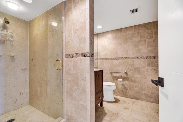 bathroom featuring tile walls, vanity, an enclosed shower, and toilet