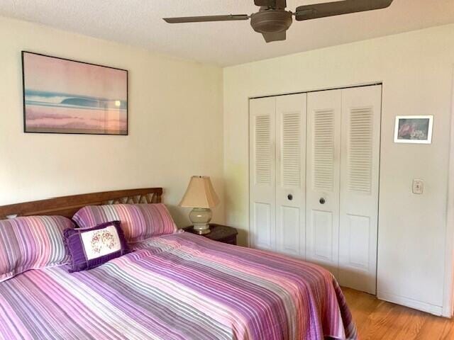 bedroom with light hardwood / wood-style floors, a closet, and ceiling fan