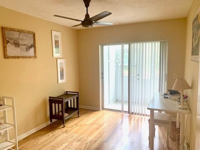 doorway to outside with light hardwood / wood-style floors, a textured ceiling, and ceiling fan