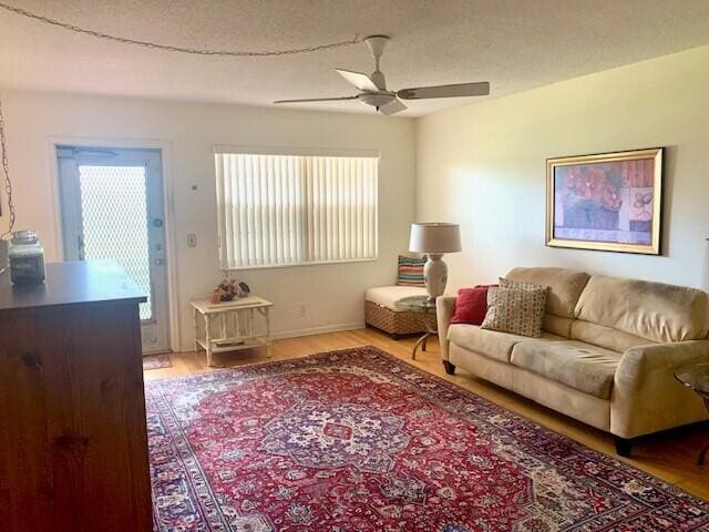 living room featuring a textured ceiling, hardwood / wood-style flooring, and ceiling fan