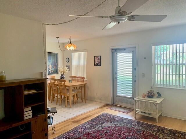 interior space with ceiling fan, wood-type flooring, and a textured ceiling