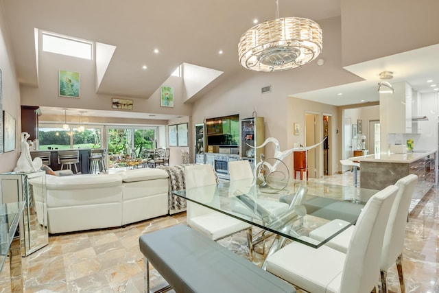 dining space with high vaulted ceiling and a chandelier