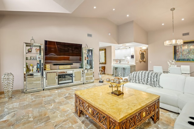 living room featuring high vaulted ceiling, a notable chandelier, and sink