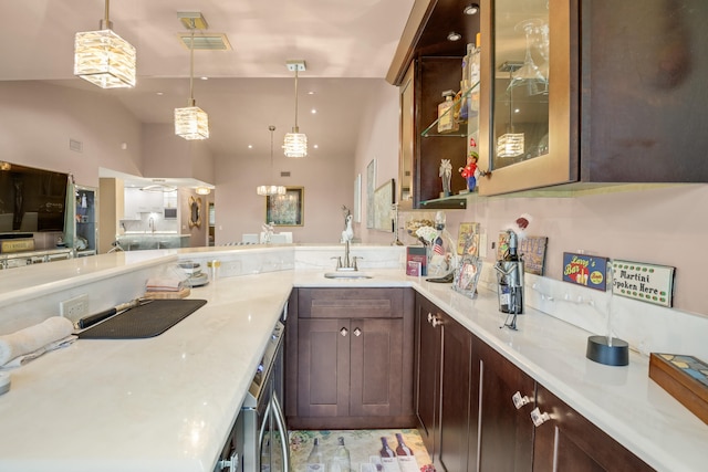 kitchen featuring kitchen peninsula, dark brown cabinetry, decorative light fixtures, and sink