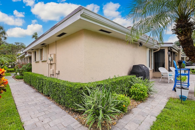 view of side of property with a patio area