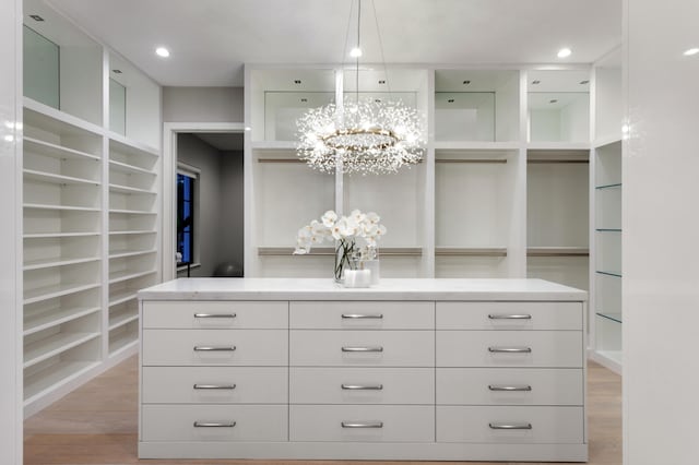 bathroom with vanity, a notable chandelier, hardwood / wood-style flooring, and an enclosed shower