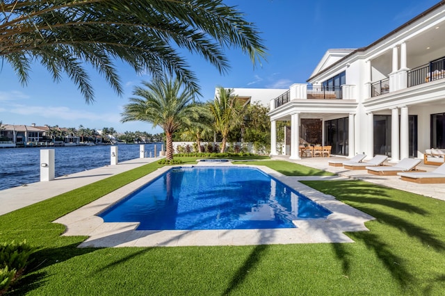 view of pool with a patio area, a yard, and a water view