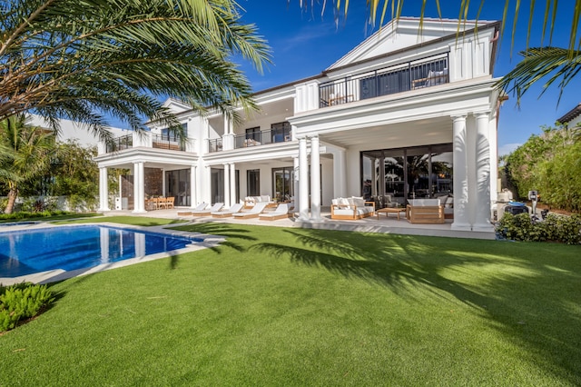 rear view of house featuring a yard, a patio area, a balcony, and outdoor lounge area